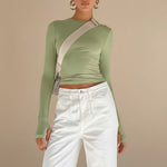 Yemelia light green long sleeve fitted top with thumbhole detail and minimalist neckline, made from stretch fabric.