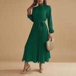 Yemelia green long sleeve pleated midi dress with high neck and waist tie. Elegant, flowing silhouette.