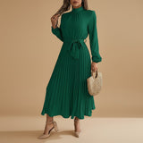 Yemelia green long sleeve pleated midi dress with high neck and waist tie. Elegant, flowing silhouette.