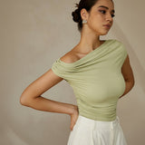 Yemelia light green ruched one-shoulder top with asymmetrical neckline and stretch fabric.