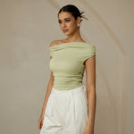Yemelia light green ruched one-shoulder top with asymmetrical neckline, made of stretch fabric.