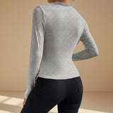 Yemelia grey long sleeve fitted top with asymmetrical neckline and ruched detailing, made from stretch fabric.