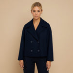 Yemelia navy blue cropped double-breasted jacket with wide lapels and decorative buttons.