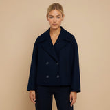 Yemelia navy blue cropped double-breasted jacket with wide lapels and decorative buttons.
