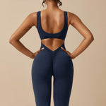 Yemelia navy blue sleeveless sculpting jumpsuit with ruched back detail and flared legs.