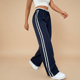 Yemelia navy blue high waist wide leg track pants with white side stripe detail and elastic waistband.