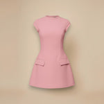 Yemelia pink structured mini dress with high neck, cap sleeves, flared skirt, and flap pockets.