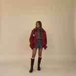 Yemelia red faux leather bomber jacket with zip front, ribbed trim, and structured silhouette.