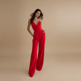 Yemelia red tailored jumpsuit with deep V halter neck and wide leg trousers. Ideal for formal events.