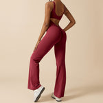 Yemelia sleeveless sculpting flared leg jumpsuit in deep red, made from smooth stretch fabric. Features a clean neckline and body-contouring fit.