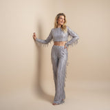 Yemelia silver sequin crop top with long sleeves and matching wide leg pants, featuring fringe detailing.