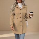 Yemelia tan tailored mid-length coat with button front, classic collar, and waist belt. Made from a structured fabric.