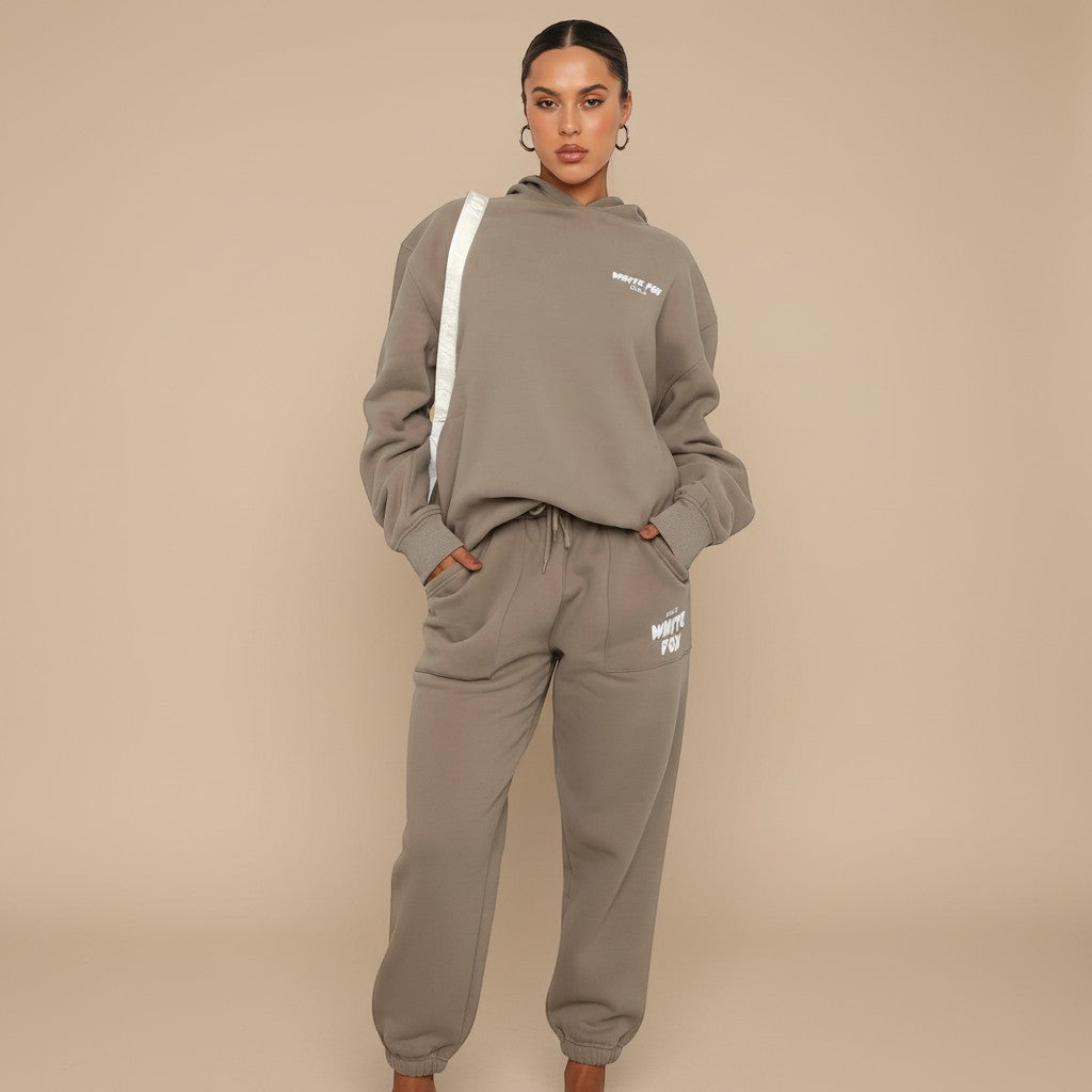 Yemelia taupe relaxed fit cotton blend hoodie and jogger set with graphic accent, elastic waistband, and drawstring.