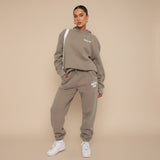 Yemelia taupe relaxed fit hoodie and jogger set with graphic accent, soft fabric, elastic waistband.