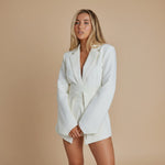 Yemelia white belted tailored blazer with relaxed fit, lapel neckline, and functional pockets. Smooth fabric.