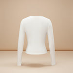 Yemelia white long sleeve fitted crop top with thumbhole cuffs, made from soft stretchy fabric.
