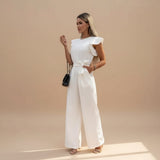 Yemelia white flutter sleeve wide leg jumpsuit with adjustable waist tie and pockets. Elegant formal wear.