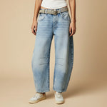 Yemelia light wash denim jeans with a relaxed fit, wide leg, and mid-rise waist. Features five-pocket styling and knee panel details.