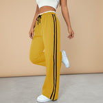Yemelia yellow high waist wide leg track pants with black side stripe detail and drawstring waist.